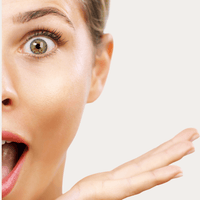 Brightening Eye Cream – Frau mit weit geöffneten Augen und überraschtem Gesichtsausdruck