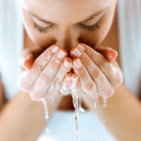 Cleansing Foam – Frau spült ihr Gesicht mit Wasser ab