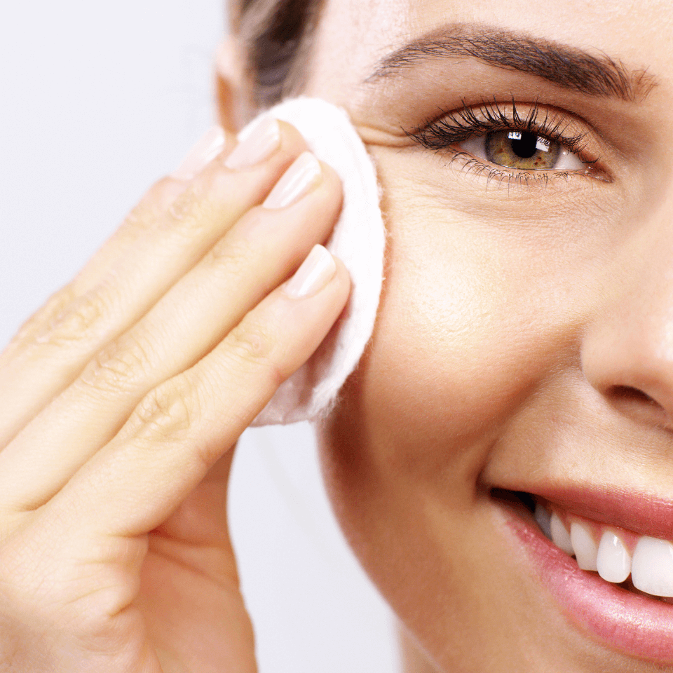 Hydrating Toner – Frau tupft Gesichtswasser mit Wattepad auf die Wange